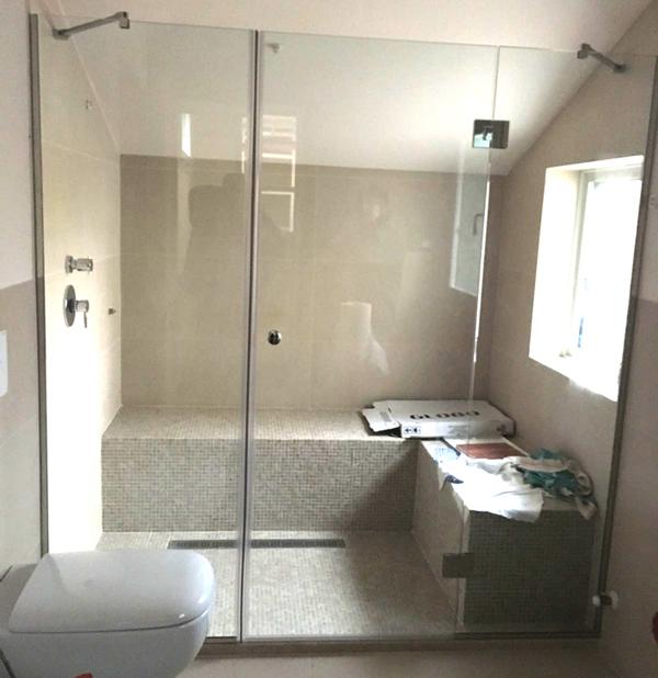 Bagno con grande porta in vetro per doccia. 